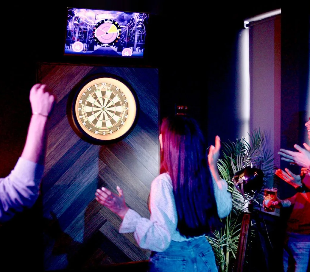 A player lining up a throw during a social game of darts